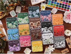 Macro shot of 16-color vintage ink pad set for rubber stamps on a rustic wooden desk