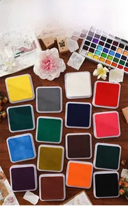 Set of 16 high-saturation square ink pads for vintage scrapbooking on dark wood surface