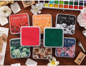Macro view of vintage style archival ink pads with floral covers on a wooden surface