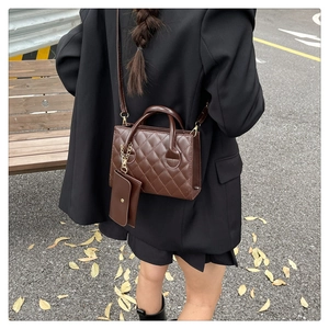 Dettaglio della borsa a tracolla trapuntata marrone scuro con mini pochette su modella