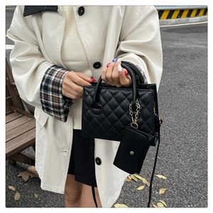 Dettaglio della borsa a mano trapuntata nera con mini pochette rimovibile e catena d'oro