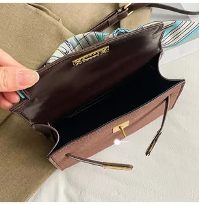 Detail view of the brown frosted leather bag interior with blue silk scarf on handle