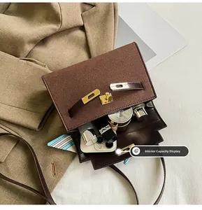 Internal capacity of the dark brown suede bag showing phone and cosmetics inside