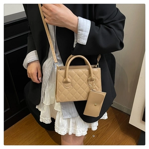 Borsa a tracolla trapuntata con mini pochette e dettagli dorati su modella