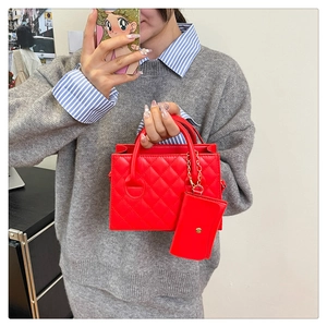 Dettaglio di borsa a mano rossa trapuntata con mini pochette e catena dorata