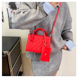 Dettaglio della borsa a tracolla rossa trapuntata con mini pochette e tracolla