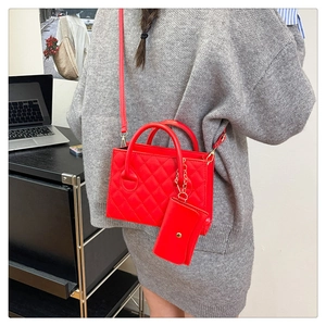 Dettaglio della borsa a tracolla trapuntata rossa con mini pochette e dettagli dorati