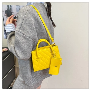 Dettaglio della borsa a tracolla trapuntata giallo brillante con mini borsellino