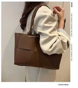 Sac seau tressé marron porté par un mannequin avec texture cuir et style épuré