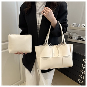 Détail du sac seau tissé crème avec pochette intérieure et fermeture à nœud élégante