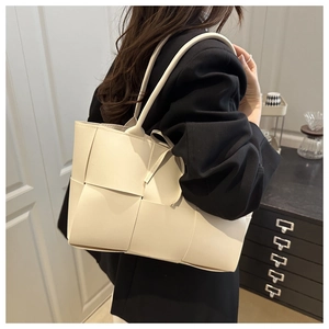 Gros plan d'un grand sac cabas tressé blanc crème avec une texture en cuir de qualité