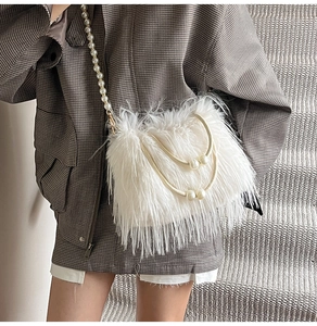 Details einer weißen Handtasche aus Kunstfedern mit eleganten Perlenriemen und Griffen
