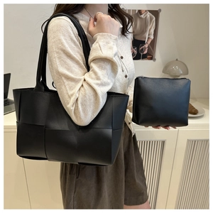 Vue détaillée du sac seau noir tressé montrant la texture et la pochette interne