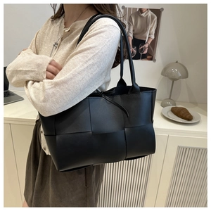 Détail du sac cabas en cuir tressé noir avec large tissage et doubles bandoulières