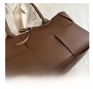 Gros plan sur la texture en cuir tressé marron d'un grand sac à main seau