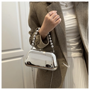 Détail du sac boîte argent miroir avec poignée en perles et bandoulière chaîne métal