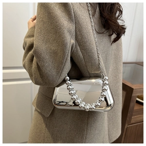 Détail du sac boîte en acrylique miroir argenté avec poignée perlée et chaîne