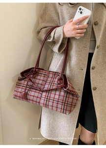 Detail of wool plaid tote bag with red leather straps and minimalist retro design