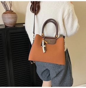 Details einer Handtasche mit Webstruktur und Perlenquaste im Retro-Lifestyle-Ambiente