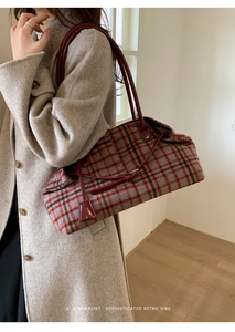 Close-up of retro plaid wool tote bag with red leather handles shown on shoulder
