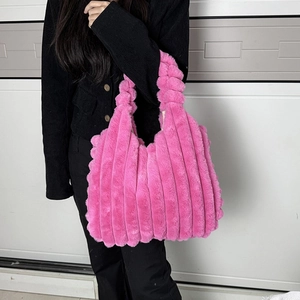 Pink plush tote bag with vertical stripes shown on a model in a minimalist setting