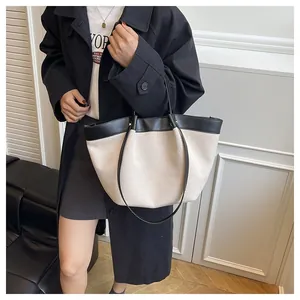Canvas tote bag with black leather trim shown on model for casual everyday style