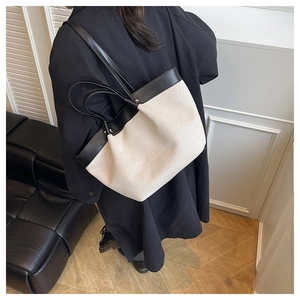 Detail of canvas tote bag with black leather trim and handles for women's daily commute