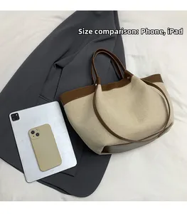 Size comparison of large tote bag with iPad and phone against a grey blazer