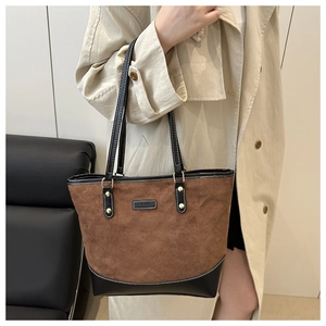 Detail of brown suede tote bag with diamond quilting and fashion patch on shoulder