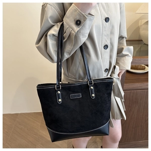 Detail of black quilted tote bag featuring frosted texture splicing and fashion label