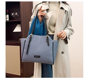Nahaufnahme der blauen Denim-Tragetasche mit verstellbarem Riemen und Metallteilen