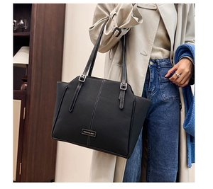 Detail der schwarzen Shopper-Tasche mit weißen Kontrastnähten und Silberbeschlägen