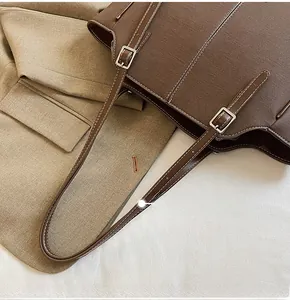 Details des verstellbaren Lederriemens und der Metallschnalle an der braunen Stofftasche