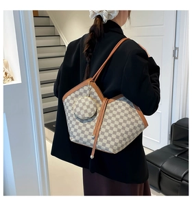 Detail of printed tote bag with matching coin purse on a model in a modern suit