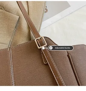 Details der verstellbaren Metallschnalle an brauner Canvas-Tasche mit Lederbesatz