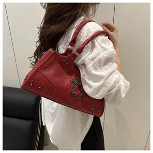 Detail view of red punk motorcycle bag with silver metal cross and stud embellishments