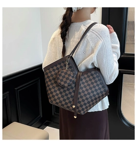 Detail shot of checkered pattern tote bag with round coin purse and gold hardware