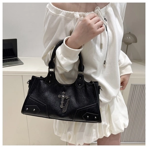 Detail der Vintage-Gothic-Handtasche mit silbernem Kreuzanhänger und Metallnieten-Akzenten