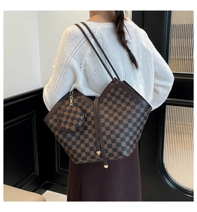 Détail d'un sac cabas à carreaux avec mini porte-monnaie porté par un mannequin