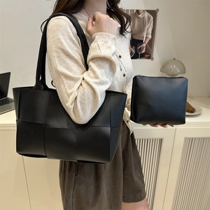 Ensemble sac seau en cuir tressé noir avec pochette intérieure dans un bureau à domicile