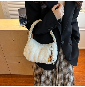 Détail d'un sac à main en peluche blanche avec anse tressée et charme en perles de bois