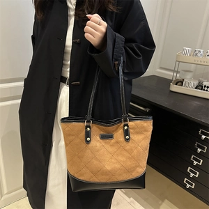 Quilted tote bag with contrast stitching and dual handles in a modern home setting