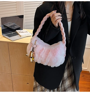 Sac à main en peluche rose avec anse tressée porté dans un cadre intérieur chaleureux