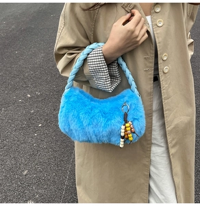 Détail d'un sac à main en peluche bleu vif avec poignées tressées et perles colorées