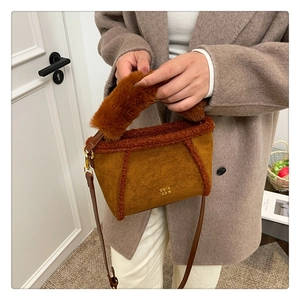Dettaglio borsa tote in pile color caramello con logo dorato e tracolla in pelle marrone