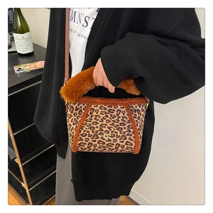 Dettaglio della borsa in peluche leopardata con bordo in pelliccia e logo oro