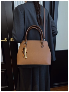Detail of brown lychee leather tote with bohemian wooden bead charm and sturdy handles
