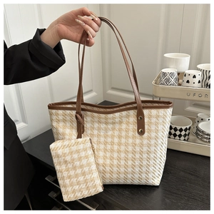 Detail of checkered woven tote bag set with brown leather handles and small matching pouch