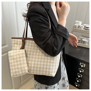 Detail of checkered tote bag set with matching pouch and brown leather handles