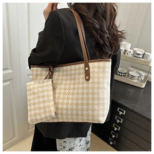 Detail of tweed check tote bag with brown leather straps and matching pouch for women